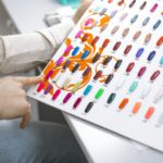 a young woman chooses a color for a manicure in a beauty salon