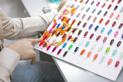 a young woman chooses a color for a manicure in a beauty salon